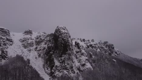 Drone-Está-Escalando-Sobre-El-Pico-De-La-Montaña-Rocosa-En-El-Invierno