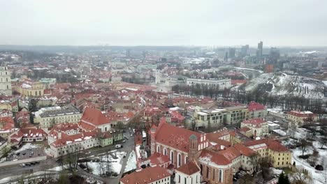 Aerial-show-flying-above-the-old-town-of-Vilnius,-Lithuania-on-a-winter-morning
