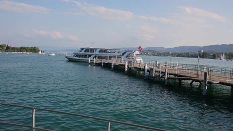 Large-ferry-boat-sails-out-from-the-pier-of-Lake-Zurich-harbour,-Switzerland