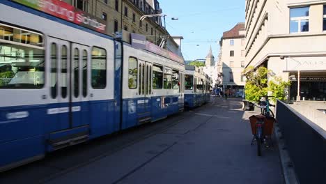 Straßenbahn-Vorbei-An-Den-Stadthäusern-Auf-Der-Hauptstraße-Der-Zürcher-Innenstadt,-Einkaufsviertel