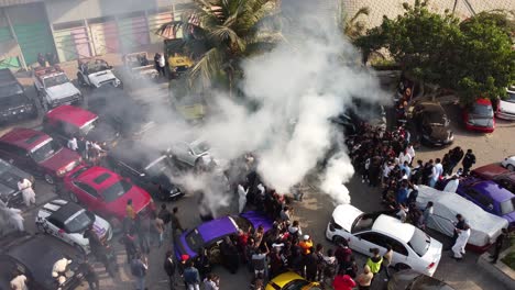 Aerial-Birds-Eye-View-Of-People-Attending-Pakwheels-Car-Show-In-Karachi-With-Car-Blowing-Flames-And-Smoke-From-Bonnet