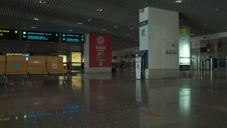 Vista-De-Izquierda-A-Derecha-De-Un-Salón-Del-Aeropuerto-Junto-A-Un-Mostrador-De-Facturación-De-Equipaje-Completamente-Vacío-En-El-Aeropuerto-De-Madeira-En-Portugal