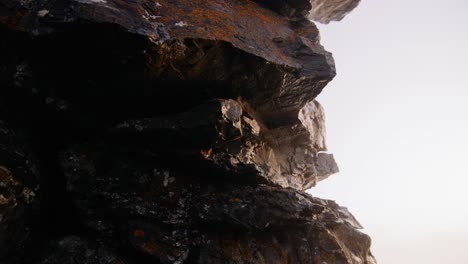 Camera-moving-around-rockformation-close-up-with-orange-moss