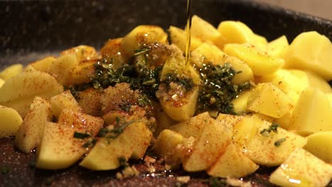 seasoning-the-cutted-potatoes-with-aromatic-herbs,-sage,-rosemary,-hot-spices-and-italian-extra-virgin-olive-oil---close-up-footage