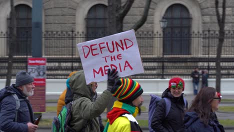 Man-holding-up-a-defund-the-media-sign-during-Corona-Protests