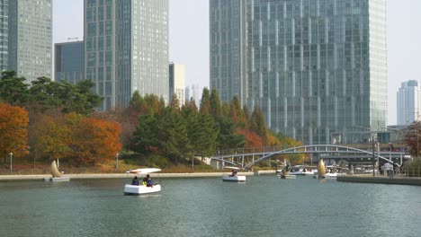 Songdo-Central-Park-in-Incheon---visitors-in-masks-cruise-on-small-Boats-at-the-lake-and-stroll-around-lake-trails-during-covid-19-coronavirus-outbreak-in-South-Korea