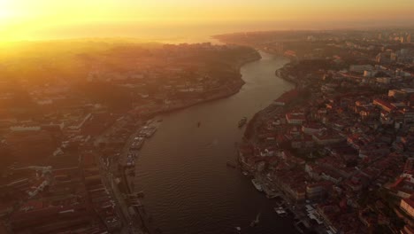 Aerial-panoramic-sunset-view-of-the-city-of-Porto-north-of-Portugal,-drone-fly-above-Douro-river-during-golden-hour
