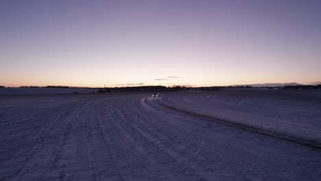 Vista-De-Pájaro-De-La-Conducción-De-Automóviles-En-Un-Camino-Nevado-En-Un-Paisaje-Invernal,-Escandinavia---Tiro-Panorámico
