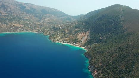 Aerial-towards-Vouti-beach-in-Kefalonia-island,-secluded-pebble-beach-with-turquoise-sea