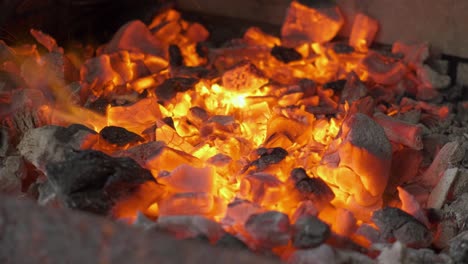A-fire-and-embers-burning-close-up-as-they-glow-with-heat
