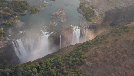 La-Niebla-Se-Eleva-Desde-El-Río-Zambezi,-Las-Cataratas-Victoria-En-Una-Vista-Aérea-Giratoria