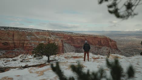 A-Man-Walking-in-the-Snowy-Canyon-while-the-storm-is-brewing-overhead
