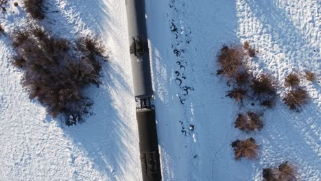 Train-oil-trailers-trough-a-marsh-in-winter-snow-followed