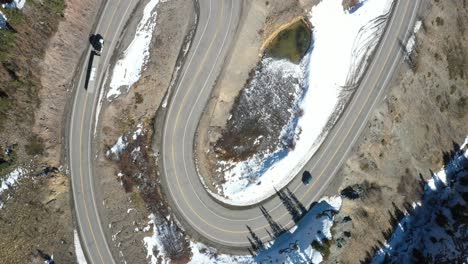 Overhead-view-of-switchback-road-on-Million-Dollar-Highway-in-Colorado-with-a-car-and-semi-truck-drone-video