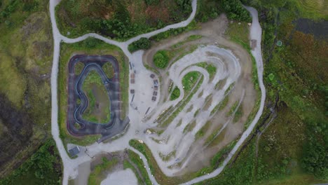 Pump-track-with-kids-riding-bicycle---Asphalt-and-gravel-tracks-at-Geilo-Norway---Static-top-down-aerial
