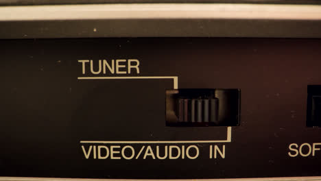 Extreme-Nahaufnahme-Einer-Taste-Auf-Einem-Alten-Videorecorder,-Der-Von-Video-Und-Audio-Auf-Einen-Tuner-Umschaltet