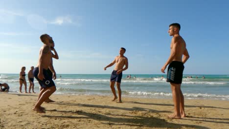 Boys-on-holidays-have-fun-playing-soccer-on-sandy-beach-in-Italy
