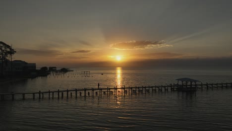 Ein-Erstaunlicher-Sonnenuntergang-über-Der-Mobilen-Bucht-Mit-Dock,-Blasen-Und-Einsamem-Fischerboot