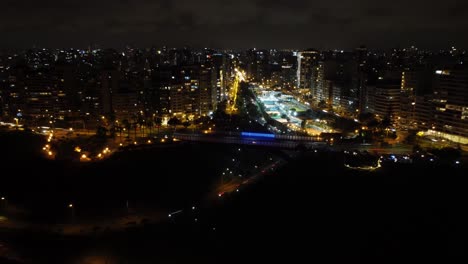Night-time-drone-hyperlapse-of-a-bridge-lit-with-LED-lights-that-change-colors
