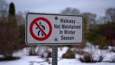 Walking-Path-Walkway-Not-Maintained-in-Winter-Season-Sign-Close-Up-Pan,-Isolated