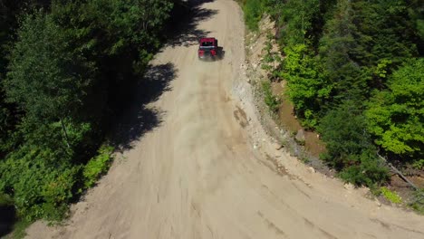Red-Off-Road-Vehicle-Drifting-on-Dirt-Terrain-in-Beautiful-Green-Forest-Captured-by-Drone
