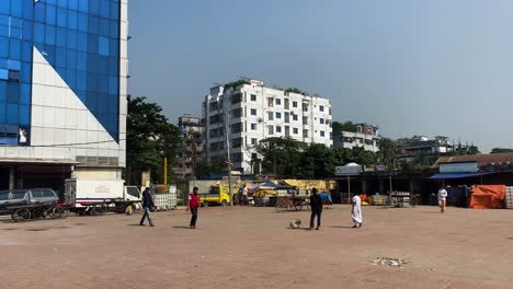 Grupo-Jugando-Cricket-En-Un-Espacio-Urbano-Abierto-Fuera-Del-Edificio-En-Dhaka,-Bangladesh