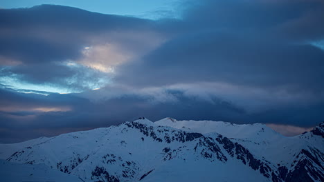 Time-lapse-shot-of-dramatic-clouds-flying-over-snowy-peaks-of-mountains-in-winter