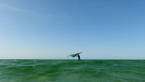 Low-Angle-Pov-Des-Mannes-Auf-Dem-Kiteboard-Flügelsurfen-Auf-Der-Meeresoberfläche