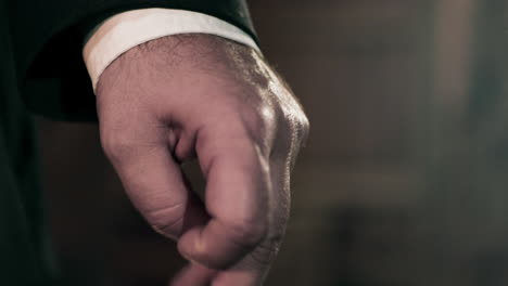 Caucasian-man-in-suit-clenching-hands-into-fist,-super-close-up-on-hands