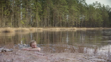 WIDE-SHOT---An-ice-bather-slips-into-the-ice-hole-he-has-made-in-the-frozen-lake