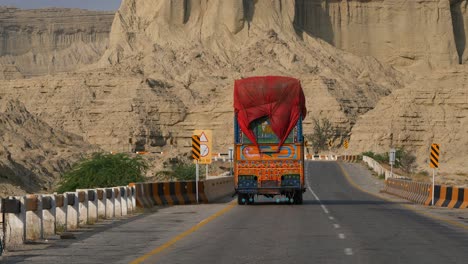 Camión-Grande-Y-Colorido-Con-Lona-Roja-Envuelta-Conduciendo-A-Lo-Largo-De-La-Carretera-Costera-De-Makran-En-Baluchistán