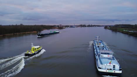 Luftaufnahme-Des-Flusspolizeiboots,-Das-Auf-Der-Oude-Mass-An-Einem-Sincero-Frachtschiff-Vorbeifährt