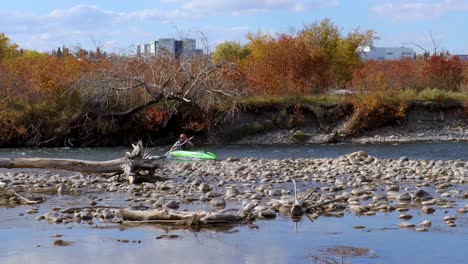 Kayaking-down-a-rapidly-flowing-river-with-a-city-in-the-background