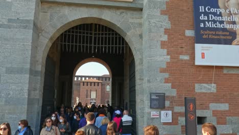 Visitors-moving-forward-entrance-of-Castello-Sforzesco-or-Sforza-castle-in-Milan,-Italy