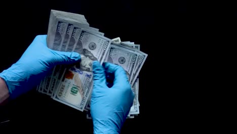 Nitrile-gloved-hands-count-a-stack-of-one-hundred-dollar-bills