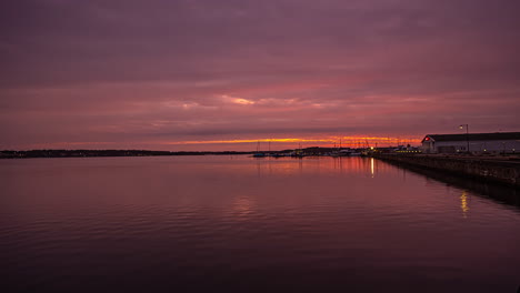 Empty-port-cloudy-sunset,-dramatic-sky-on-a-harbor-side-of-water,-still-shot-timelapse
