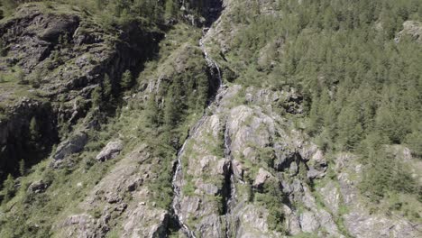 Video-De-Un-Avión-Grúa-O-Ascenso-Con-Vista-De-Pájaro-Al-Final-Con-Un-Dron-Volando-Sobre-Una-Cascada-En-Los-Alpes-Italianos