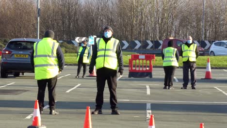 Covid-medical-staff-wearing-face-masks-working-on-test-centre-car-park-during-healthcare-crisis