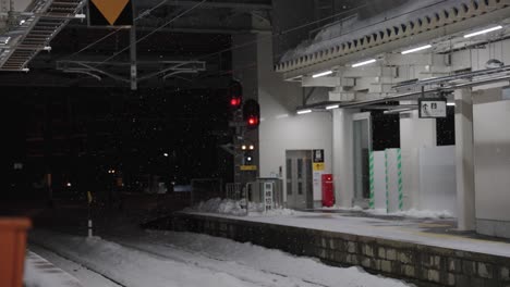 Snow-falling-over-Aomori-Train-Station-at-night,-Heavy-Winter-Storm-in-Japan