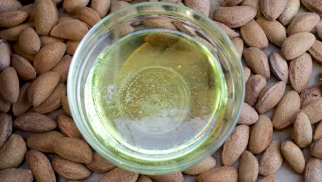 Almond-Oil-is-poured-into-transparent-bowl,-view-from-above
