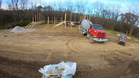 Time-lapse-of-construction-crew-pouring-concrete-to-anchor-principal-framing-poles-for-new-construction-of-a-pole-barn