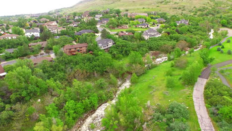 beautiful-drone-aerial-of-a-trail-and-river-at-the-edge-of-the-suburbs-near-some-mountains