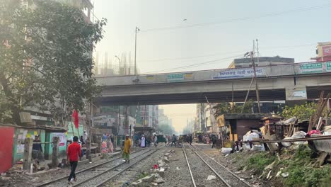 Blick-Von-Den-Gleisen-Der-Überführungsbrücke-Mit-Einheimischen-Und-Rikschas,-Die-Darunter-In-Dhaka-Kreuzen