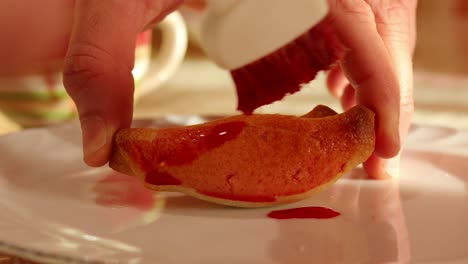 decorating-the-italian-stuffed-pastries-with-red-liqueur-using-a-pastry-brush,-close-up-shot