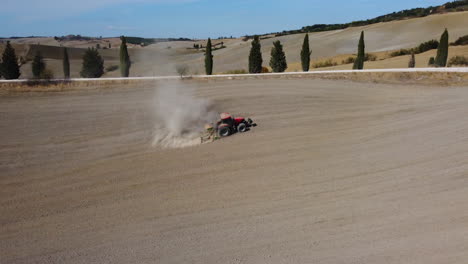 Tractor-preparing-wheat-rural-field,-plowing-ground-soil-aerial-view