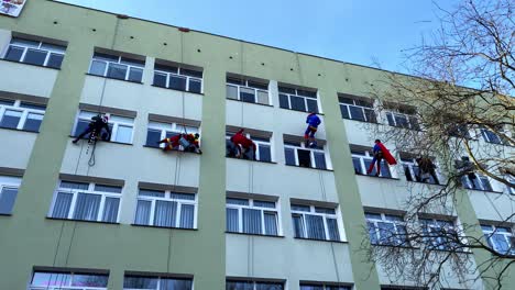 Eine-Gruppe-Von-Freiwilligen-Mit-Spezieller-Kletterausrüstung-Putzt-Fenster-In-Einem-Kinderkrankenhaus-In-Danzig