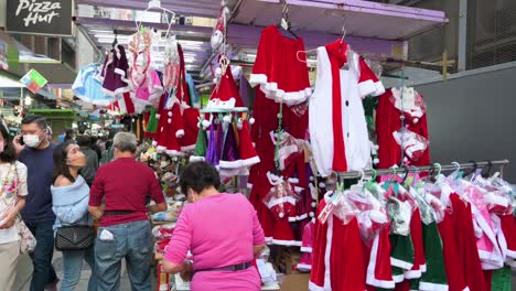 A-street-vendor-is-seen-organizing-Christmas-merchandise-for-sale-such-as-hats,-ornaments,-and-costumes-in-Hong-Kong
