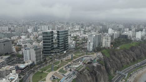 Aerial-pan-over-dense,-foggy-Pacific-coastal-city-of-Miraflores,-Peru