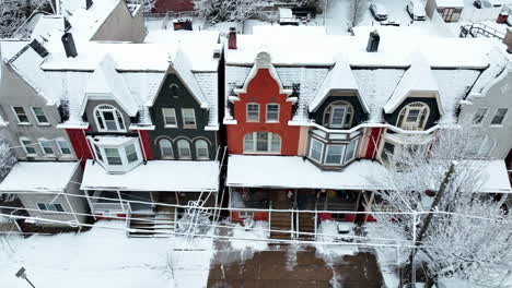 Truck-shot-of-colorful-old-Victorian-homes-in-winter-snow