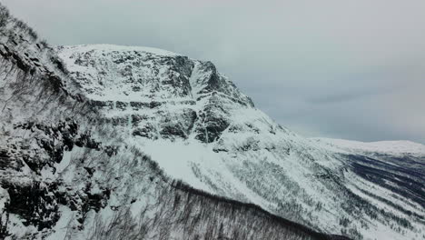 Drone-shot-flying-over-snow-covered-mountains-in-Troms-og-Finnmark,-Norway